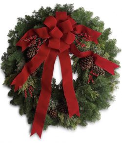 a classic holiday wreath with holly berries and red bow.