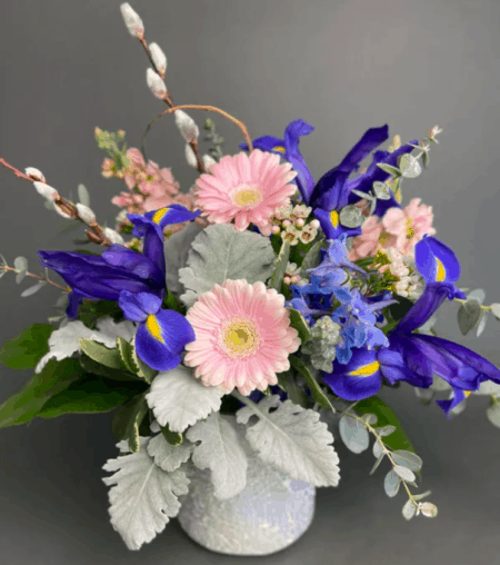 No rain, no flowers... Celebrate the spring season with this arrangement inspired by raindrops and spring blooms. This beautiful mosaic cylinder reflects all the colors of morning dew while mixed spring flowers make us so excited for the change of seasons. Featuring soft pink and vibrant purple hues.