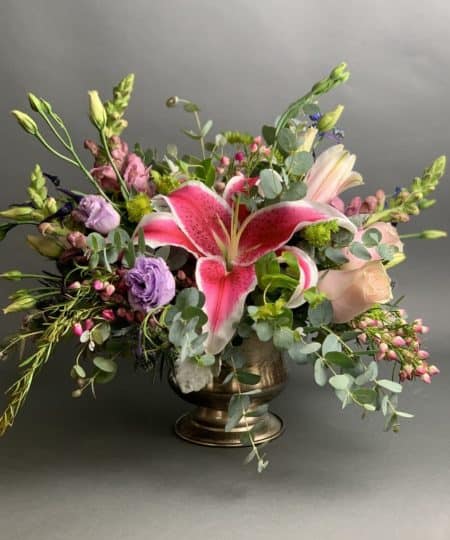 Lush, romantic, bold, beautiful. This all around design is perfect for any occasion or location. A mix of vibrant and soft pinks and purples with stylish greenery in an attractive compote vase. 