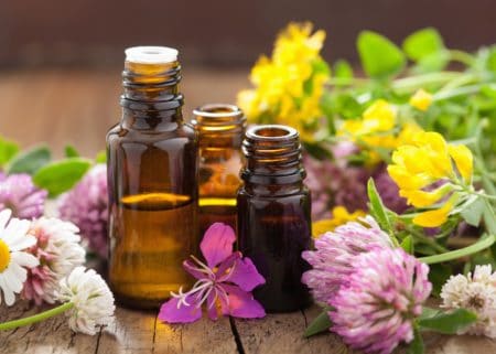 3 bottles of essential oils with flowers