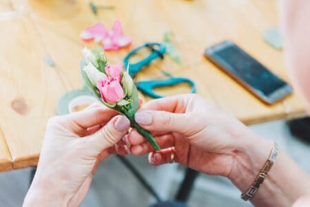 Hand holding pink flower for corsage