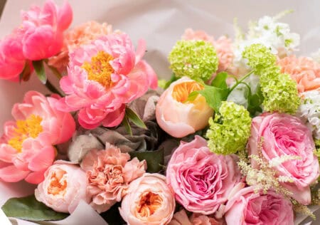 Flower shop. Beautiful bouquet of mixed flowers in man hands. The work of the florist at a flower shop. Delicate bright color. Fresh cut flower.